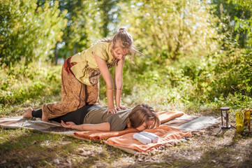 Experienced masseuse performs a relaxing massage in nature.
