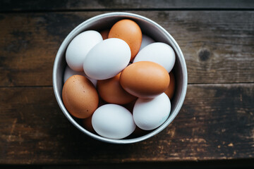 White and brown eggs on wooden table