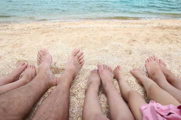 A Legs of the beautiful whole family on the sand near the sea background