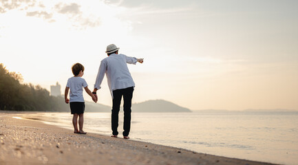 father is holding hands their child and walking on the beach at sunset in holiday..Holiday Family on the beach in summer, Travel, vacation and lifestyle concept