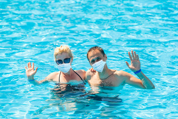 Vacation and technology. Happy familyin medical mask with kid together near swimming pool. Tourists fear the 2019-ncov virus. Medical masked tourists