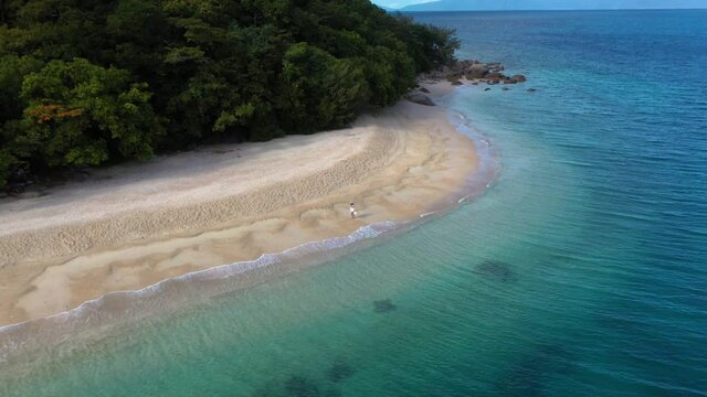 Revealing drone shot of woman walking on Nudey Beach on Fitzroy Island