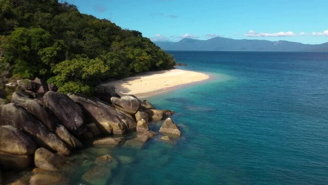 Cinematic drone shot of woman walking on Nudey Beach on Fitzroy Island