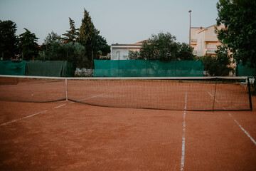 Tennis field is empty in warm weather outside