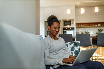 Woman enjoying at home, kitchen in the background.