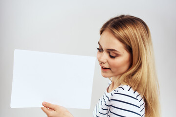 Naklejka premium woman holding a sheet of paper in her hands lifestyle striped t-shirt cropped view Copy Space