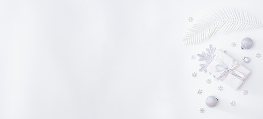 Flat lay frame with christmas baubles decoration and gift box on a white background