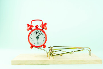 red alarm clock in a mousetrap, the concept of a time trap