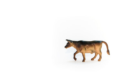 Toy cow model isolated on white background. Small cute toy close-up. Year of the bull.