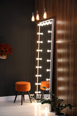 Full length dressing mirror with lamps and stool in stylish room interior