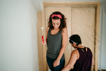 Fototapeta premium .Young lesbian couple painting the walls of their new home. Starting a life together. Do it yourself. Lifestyle