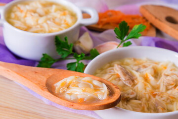 noodle soup with chicken and wooden spoon with soup