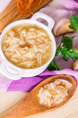 noodle soup with chicken and wooden spoon with soup