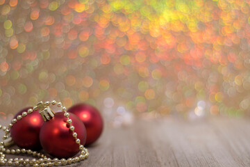 Three red ornaments on board golden bokeh for holiday sale, christmas background copy space