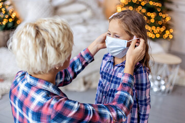 Mom puts on a protective mask for the child. Pandemic coronavirus lockdown self-isolation. The...