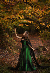 Elf in green dress in autumn forest