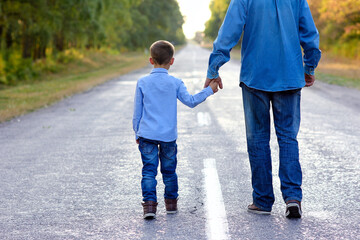 A Happy parent with a child in the park hands on nature travel go along the road