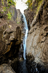 longtime exposure of waterfall and rocks in landscape - 389714447