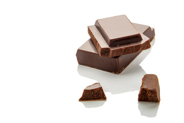 Pieces of natural dark chocolate on a white background. Copy space