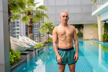 Mature handsome muscular Persian man shirtless and ready to swim