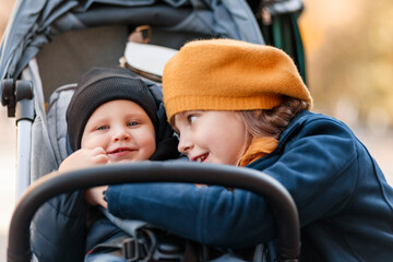 Little girl with her little brother. The girl is playing with a little boy