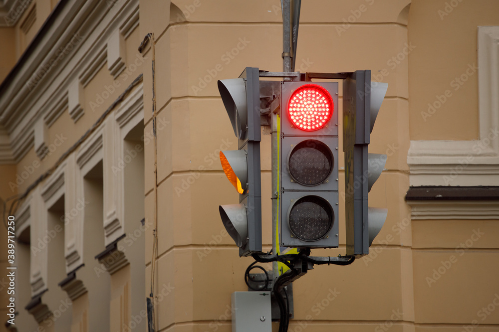 Poster traffic light on the street with a burning red signal.