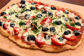 homemade pizza, vegetarian food, baked vegetables and cheese, tomatoes and olives, delicious food on a wooden background