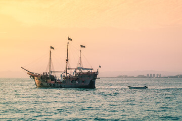 Barco pirata paseando turistas en la costa de Puerto Vallarta, al atardecer.