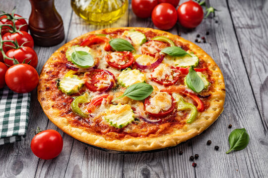 Close up of delicious crispy vegetarian pizza on rustic wooden background