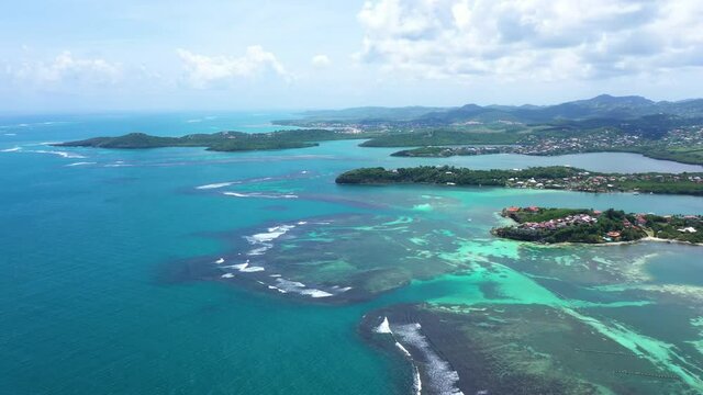 Beautiful Martinique coastline aerial view with blue lagoon coral reefs residential houses and mountains 