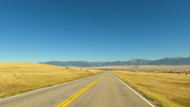 Driving plains of Montana mountain valley POV 4K. Along the Madison River in rural Montana near Yellowstone National Park. Originally a gold mining town. Tourism and outdoor recreation destination.