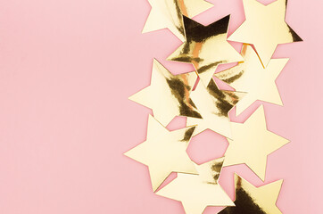 Luxury glamour gold stars on soft light pastel pink festive background, flat lay, border.