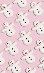 Obraz premium Vertical pattern of Christmas cookies in the shape of snowman decorated with icing sugar and fondant on a pink background