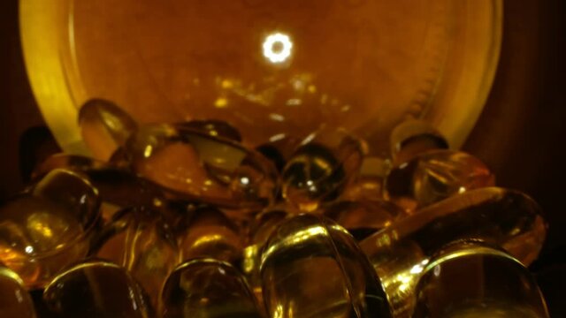 transparent yellow capsules with liquid vitamin inside the jar.
