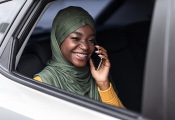 Comfortable Transport. Black Muslim Woman Having Car Ride And Talking On Cellphone