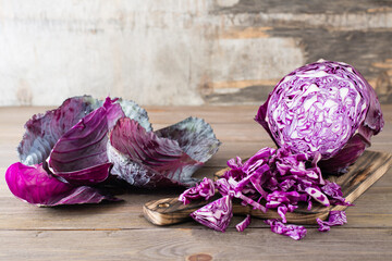 Sliced head of red cabbage on a cutting board on a wooden table