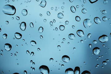 Regentropfen auf blauem Glas