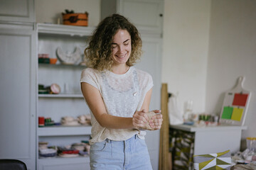 young curly girl in a pottery workshop makes a vase