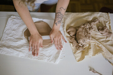 young curly girl in a pottery workshop makes a vase