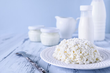 Fresh homemade cottage cheese, close-up. Set of dairy farm products on a blue background. Copy...