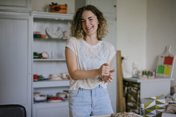 young curly girl in a pottery workshop makes a vase