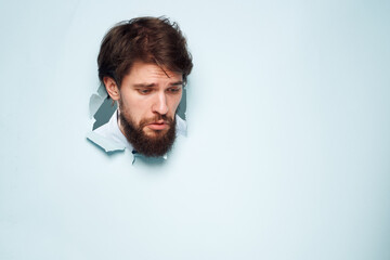 A disgruntled man head peeps out from behind the wall of an office career lifestyle