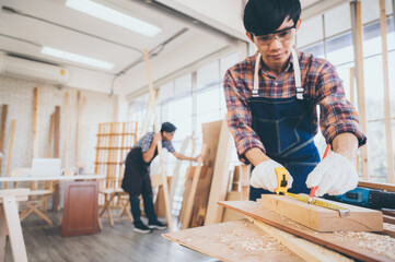 Carpenter working on woodworking machines in carpentry shop