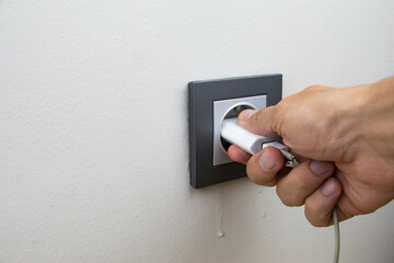 close up photo revealing that a person is plugging in or unplugging to charge/discharge of a battery
