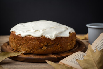 Autumn Homemade Apple Cake with white cream on a rustic table