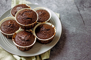 Homemade gluten-free muffins with chocolate close-up. Gluten-free flour cupcakes with chocolate on a green plate with a napkin on a dark table. Low Carb Sugar Free Cupcakes