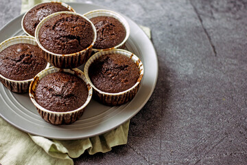 Homemade gluten-free muffins with chocolate close-up. Gluten-free flour cupcakes with chocolate on a green plate with a napkin on a dark table. Low Carb Sugar Free Cupcakes