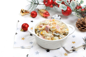 Christmas new year food, traditional festive olivier salad with fir branches and cones and decorations on a light table, idea for dish design,