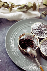 Gluten-free pumpkin chocolate muffins on a gray plate surrounded by ingredients, next to a white card for the inscription. Copy space, flat lay. Healthy baking concept