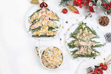 Christmas new year food, traditional festive olivier salad with fir branches and cones and decorations on a light table, idea for food design, place for recipe, flat lay,